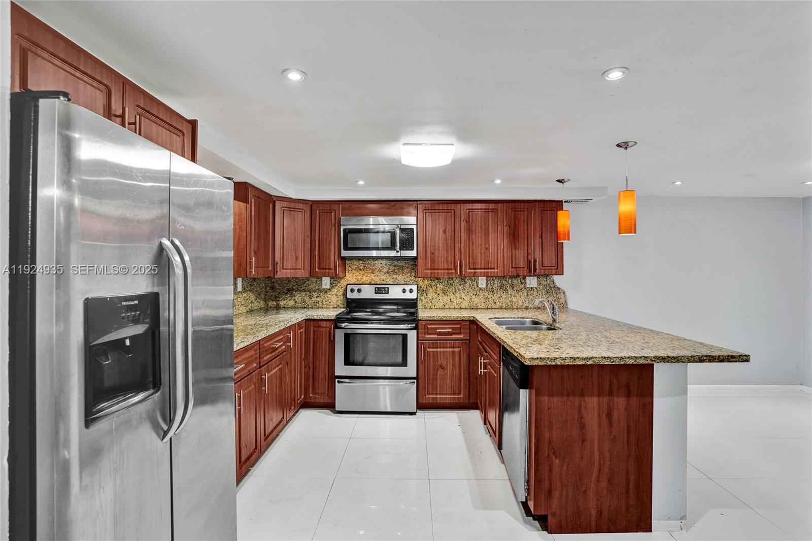 20607 Northeast 7th Court Miami, FL 33179 - Photo 4 of 49 a kitchen with stainless steel appliances granite countertop a refrigerator a sink a stove and wooden cabinets
