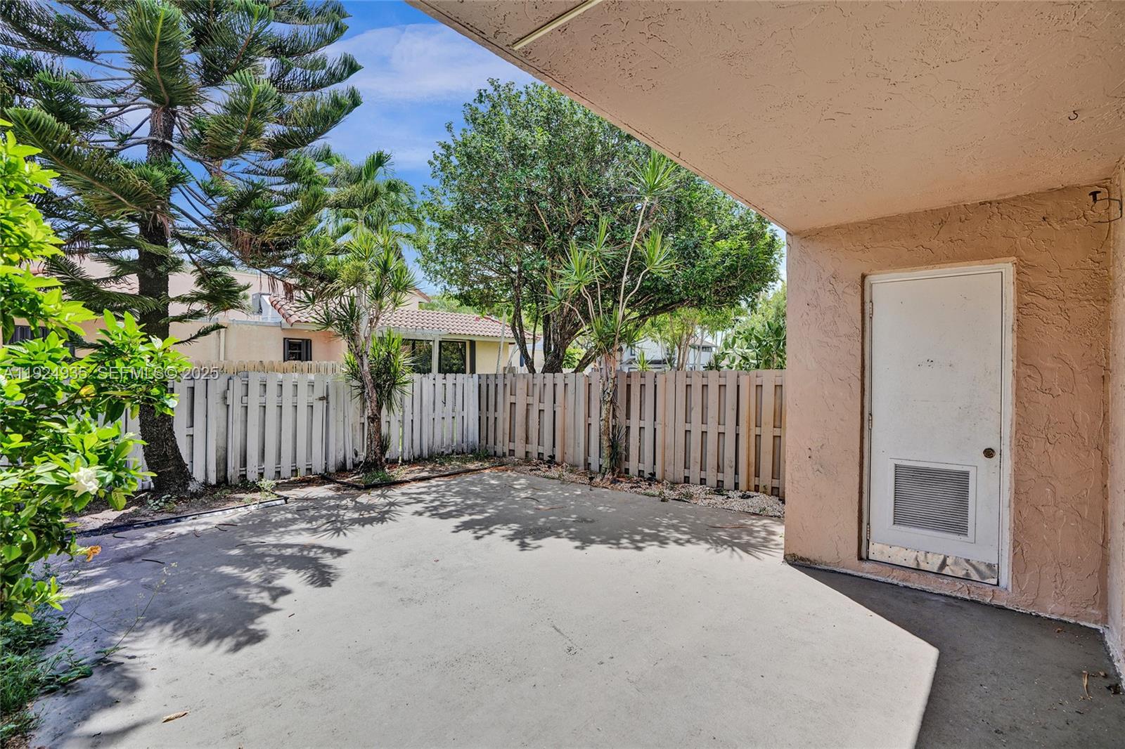 20607 Northeast 7th Court Miami, FL 33179 - Photo 43 of 49 a view of a backyard with wooden fence and a large tree