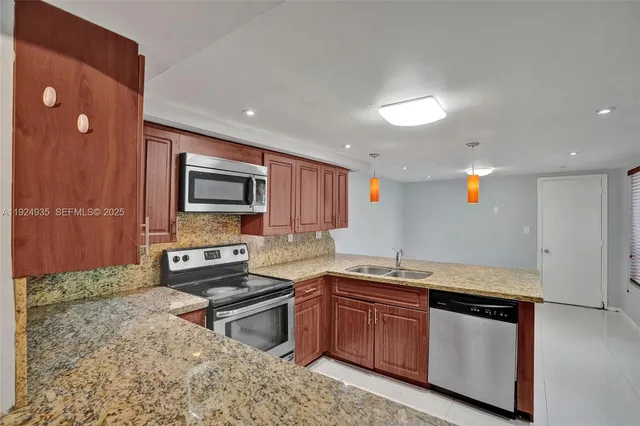 a kitchen with granite countertop a sink and a stove top oven