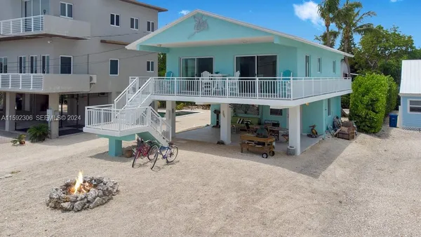 a view of a patio with table and chairs under an umbrella