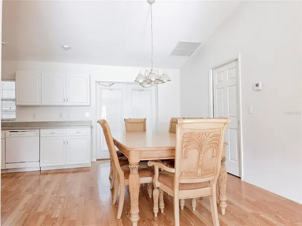 a dining room with furniture wooden floor a rug and a chandelier