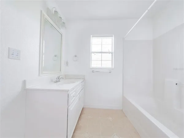 an aerial view of a house with a yard and a large tree