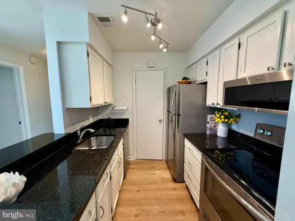 a kitchen with stainless steel appliances a sink stove and refrigerator