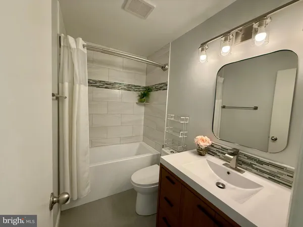 a bathroom with a sink toilet tub and shower