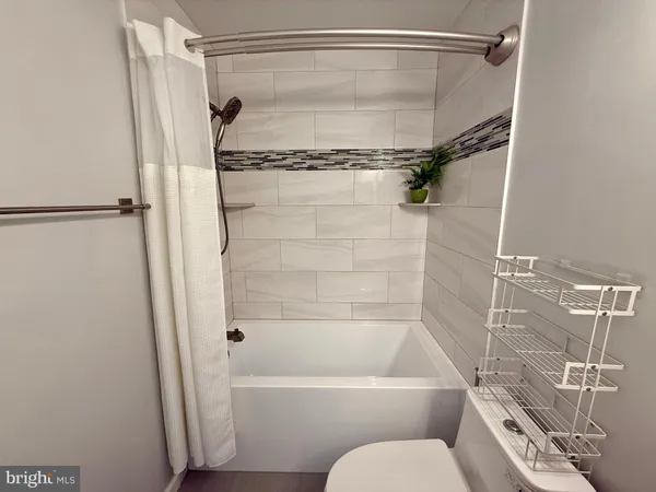 a bathroom with a shower toilet and tub