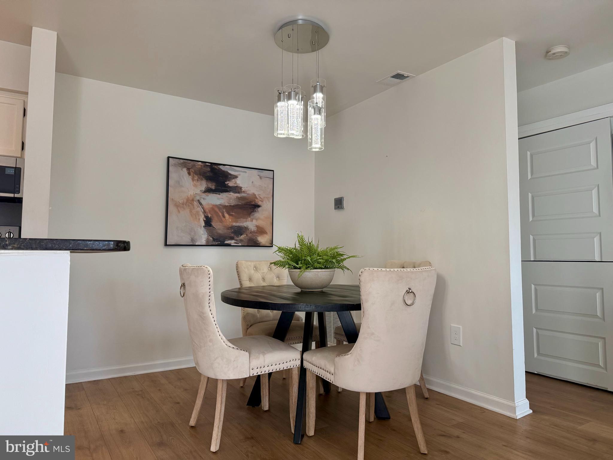5355 Smooth Meadow Way, Unit 5 Columbia, MD 21044 - Photo 9 of 26 a dining room with furniture a rug and a chandelier