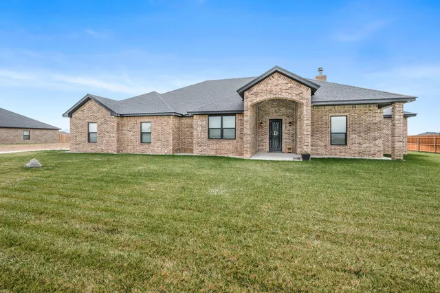 a view of a house with a big yard and large trees