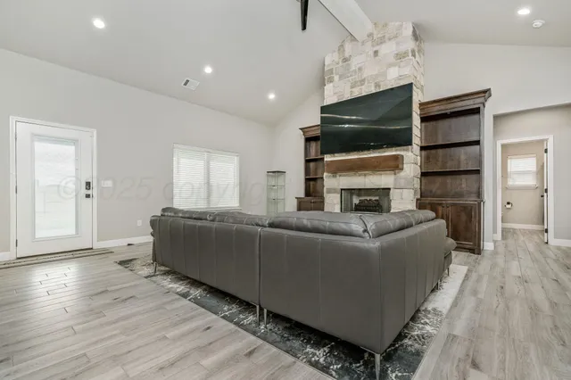 a living room with furniture a flat screen tv and a fireplace