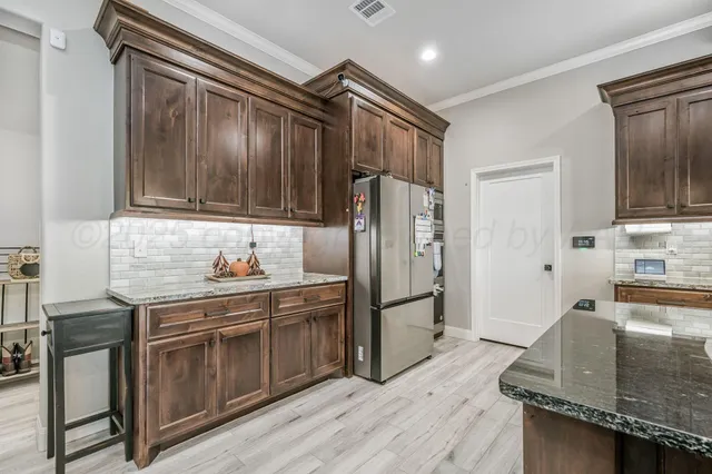 a kitchen with stainless steel appliances granite countertop a refrigerator stove and sink