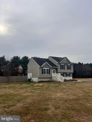 a front view of a house with a yard and lake view