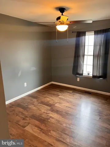 en empty room with wooden floor and window