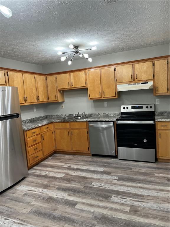 333 Forsyth Street, Unit A Barnesville, GA 30204 - Photo 3 of 5 a kitchen with granite countertop a sink cabinets and stainless steel appliances