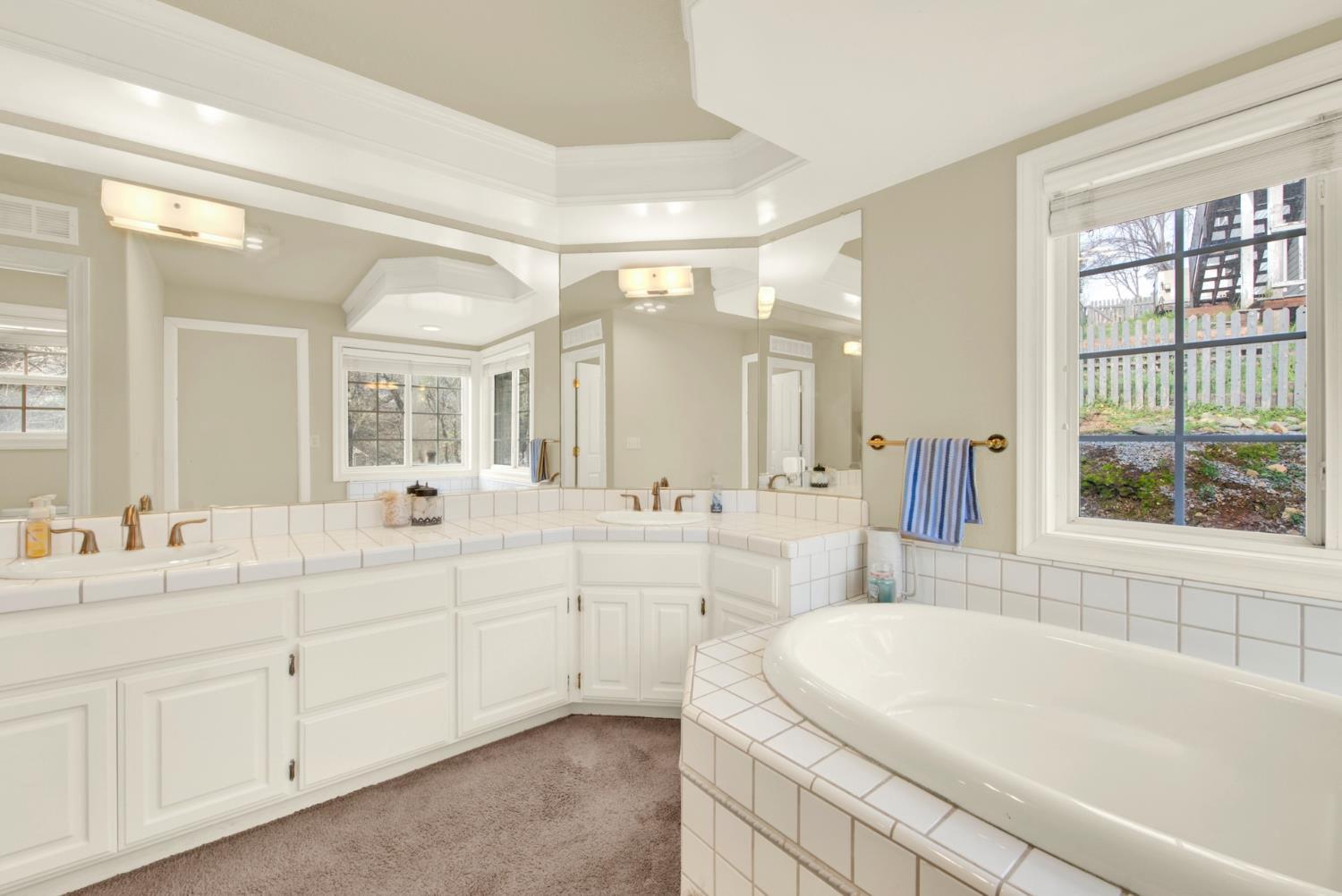 2812 Bronzecrest Street Placerville, CA 95667 - Photo 40 of 74 a spacious bathroom with a double vanity sink a large mirror and a bathtub
