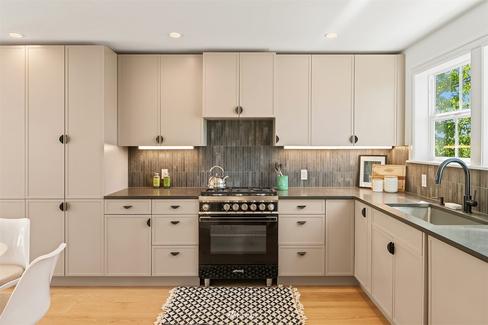 8041 Stroud Avenue North, Unit B Seattle, WA 98103 - Photo 11 of 29 a kitchen with granite countertop a stove sink and cabinets
