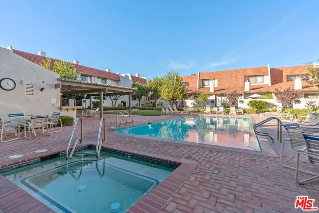 a view of a patio with a table and chairs and a barbeque