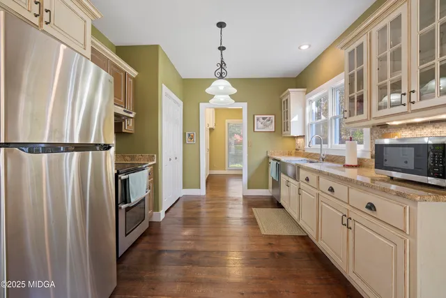 a kitchen with stainless steel appliances granite countertop a refrigerator a stove and a sink