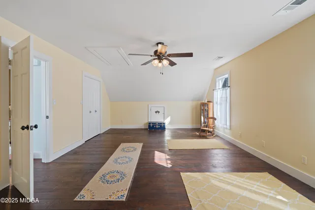a view of a living room and a ceiling fan with wooden floor