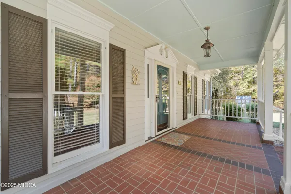 a view of a porch with wooden floor and iron stairs