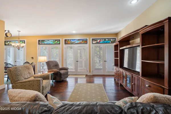 a living room with furniture hardwood floor and a flat screen tv
