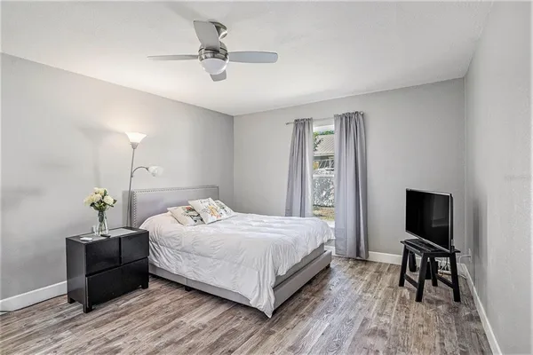 a bedroom with a bed and a flat tv screen on the dresser