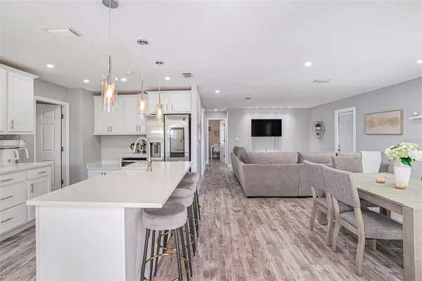 a large living room with stainless steel appliances kitchen island granite countertop furniture and a kitchen view