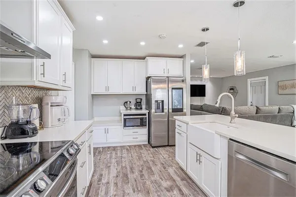 a kitchen with white cabinets and sink