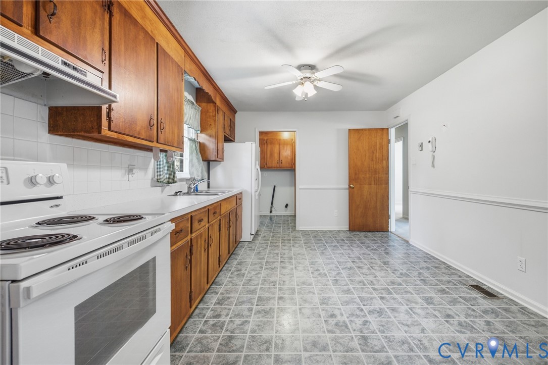 Kitchen featuring wood cabinetry, white appliances