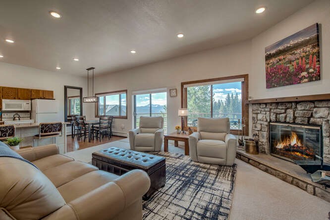 Carpeted living area with recessed lighting and a stone fireplace