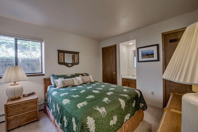 98000 Ryan Gulch Road, Unit E104 Silverthorne, CO 80498 - Photo 13 of 31 Bedroom with ensuite bathroom and light colored carpet