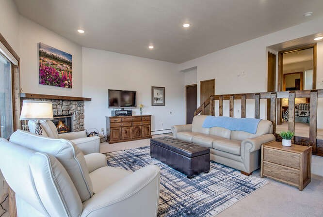 98000 Ryan Gulch Road, Unit E104 Silverthorne, CO 80498 - Photo 4 of 31 Carpeted living room featuring a stone fireplace, and recessed lighting