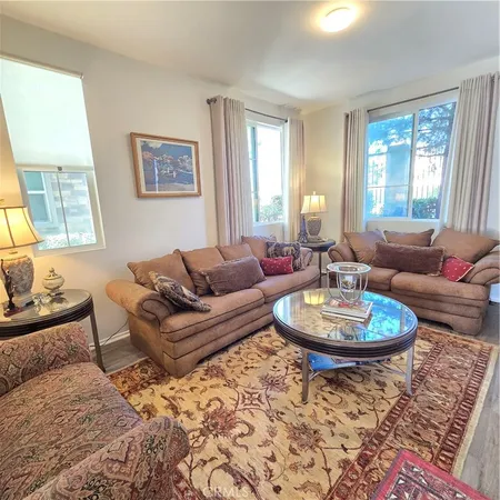 a living room with furniture a window and a lamp