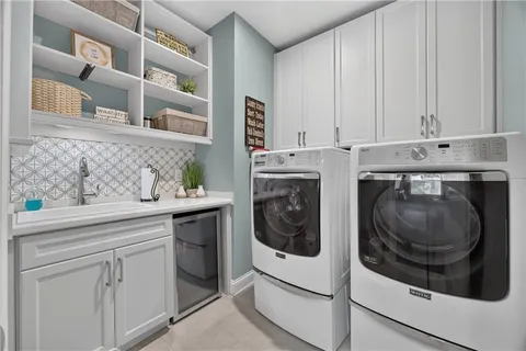 a utility room with cabinets dryer and washer