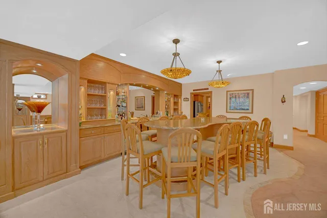 a dining hall with stainless steel appliances kitchen island granite countertop a table and chairs