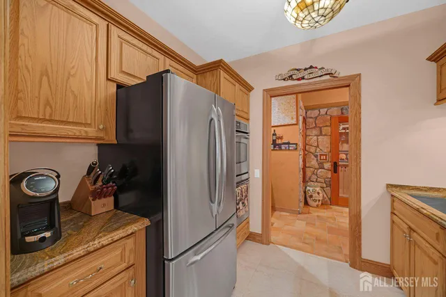 a kitchen with stainless steel appliances granite countertop a refrigerator a stove and a sink