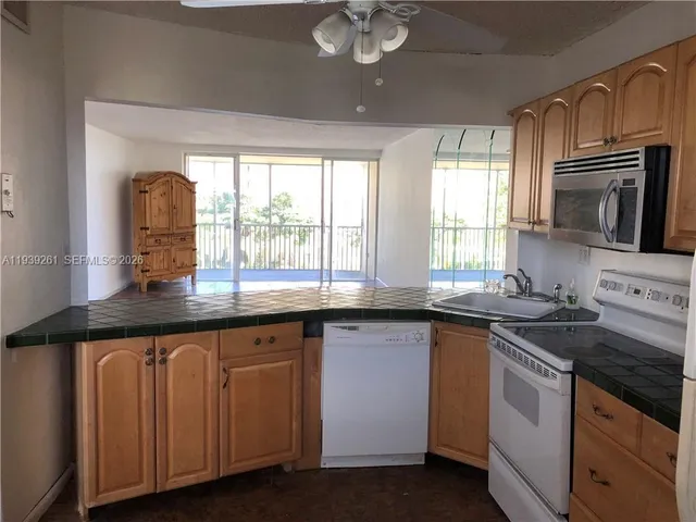 a kitchen with granite countertop a stove sink and microwave
