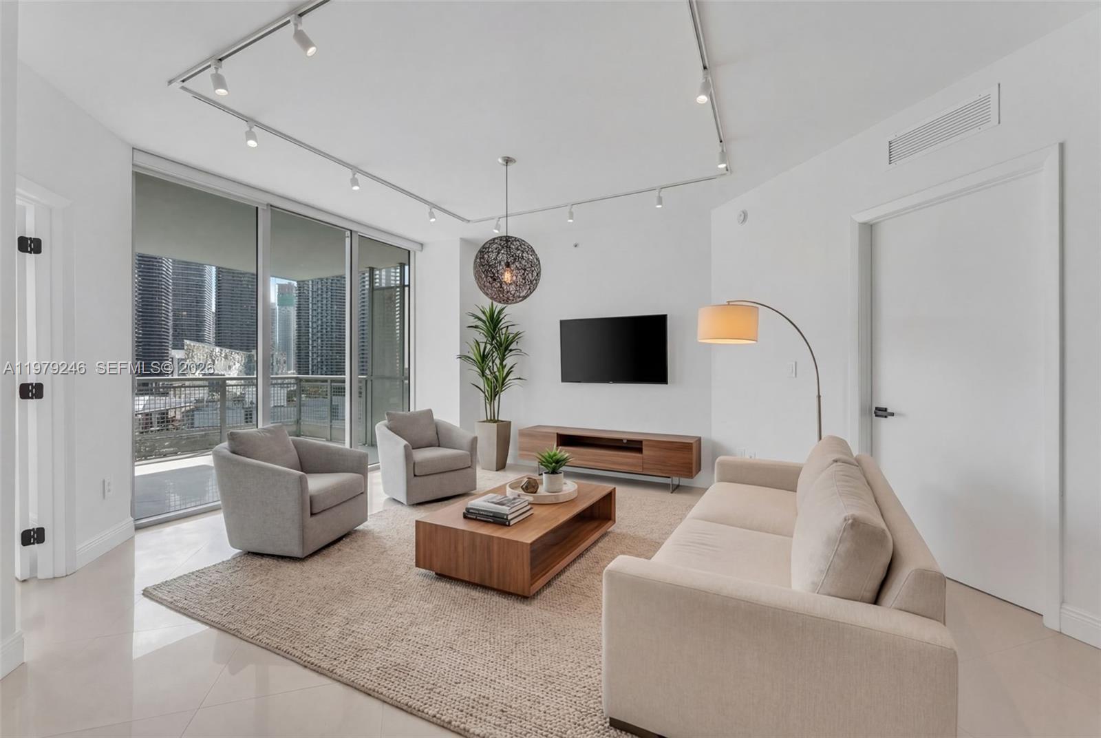 350 South Miami Avenue, Unit 2006 Miami, FL 33130 - Photo 10 of 33 a living room with furniture and a flat screen tv