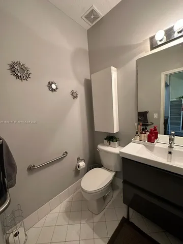 a bathroom with a sink mirror vanity and toilet