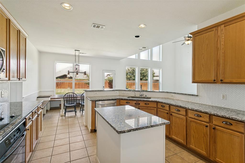 4107 Waverly Road Corinth, TX 76208 - Photo 11 of 30 The spacious kitchen features plenty of cabinets for storage, tons of counter top prep space, and an oh-so-handy island offering practical serving space.