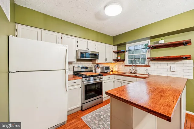 a kitchen with stainless steel appliances granite countertop a refrigerator a stove top oven a sink and dishwasher
