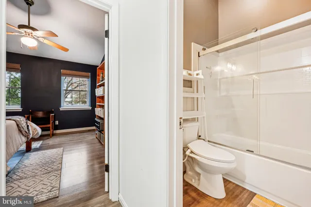 a bathroom with a toilet sink a mirror and shower