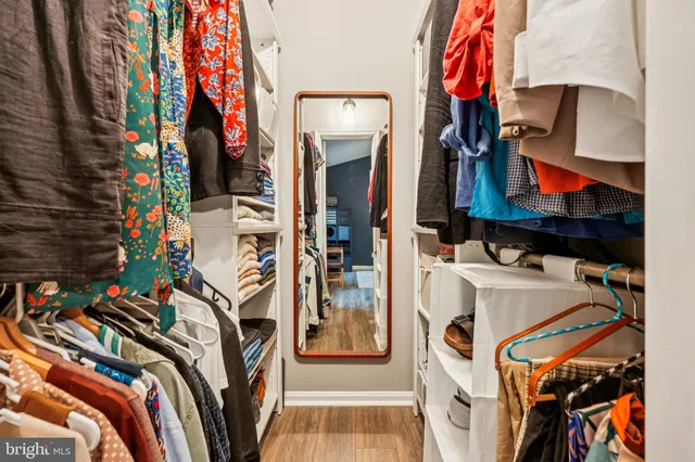 a view of walk in closet with clothes and shoes