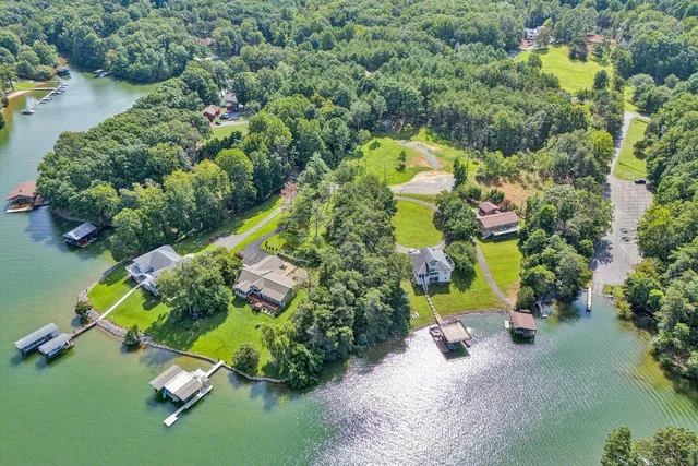 an aerial view of a house with a yard and lake view
