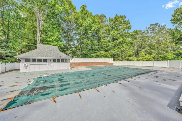 a view of a house with a yard and large trees