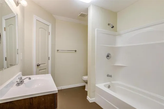 a bathroom with a bathtub shower and toilet