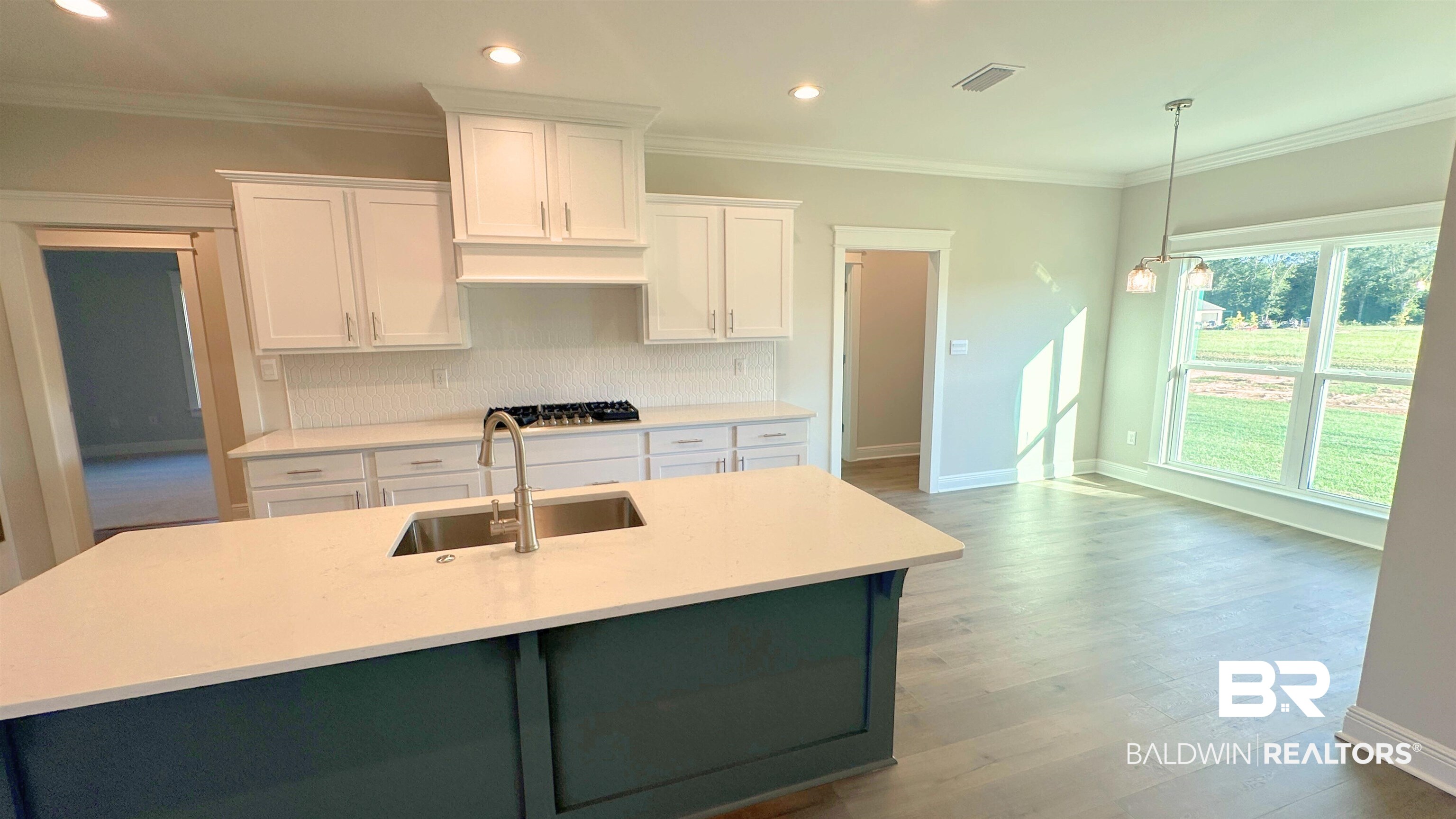 126 Daybreak Trail Fairhope, AL 36532 - Photo 10 of 34 Kitchen featuring white cabinetry, crown molding, recessed lighting, light wood finished floors, and pendant lighting