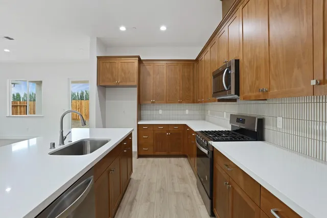 a kitchen with granite countertop cabinets stainless steel appliances a sink and a counter space