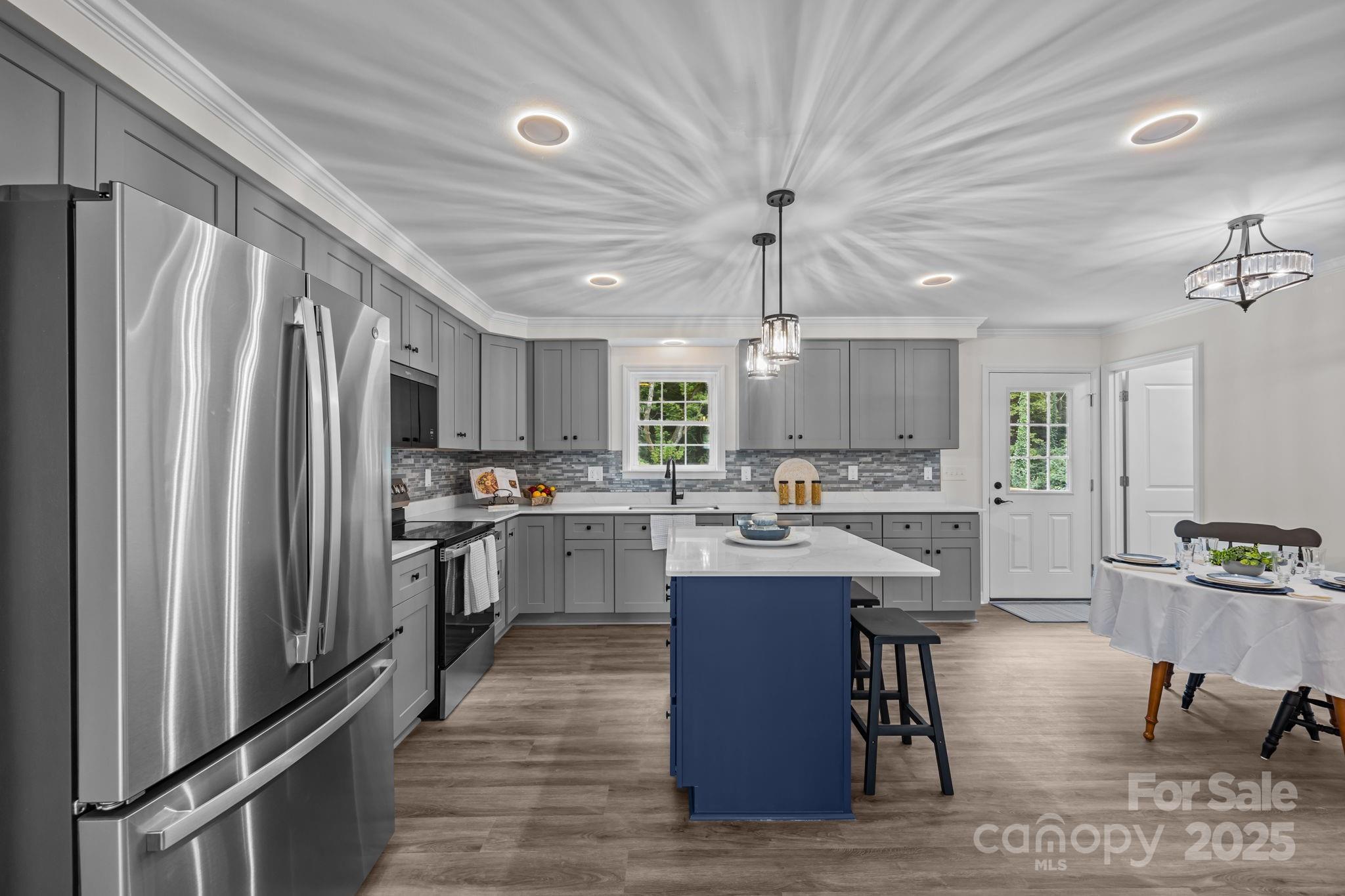 215 McCoy Cove Road Black Mountain, NC 28711 - Photo 18 of 42 a kitchen with stainless steel appliances kitchen island granite countertop a refrigerator a stove top oven a sink dishwasher and chairs with wooden floor