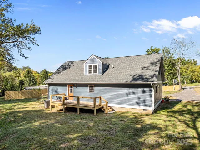 a view of a house with pool lawn chairs and a yard