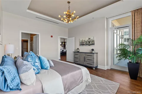 a spacious bedroom with a large bed and a chandelier