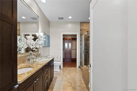 a bathroom with a granite countertop sink a mirror and a shower